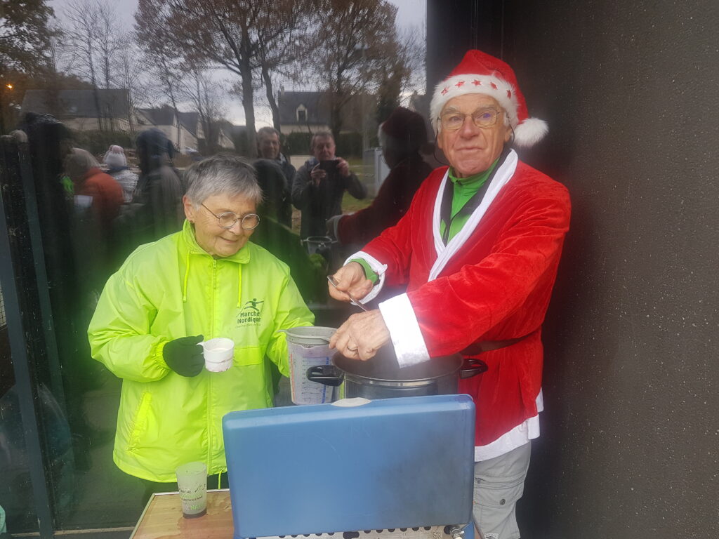 Guy en tenue de Père Noël sert le vin chaud à Annie